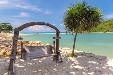 Wooden swinging bench on a beach. Thailandの写真素材
