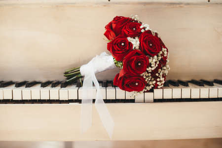 The bridal bouquet from roses lies on piano keysの写真素材