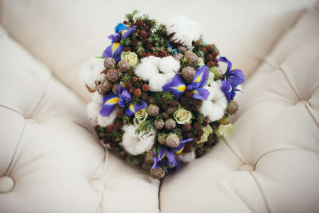 Beautiful winter wedding bouquet with cones, cotton and spruce branches. Bride holding a bridal bouquet.の写真素材