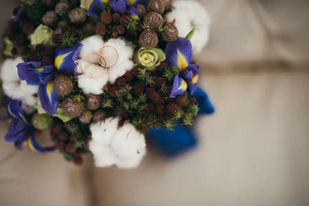 Beautiful winter wedding bouquet with cones, cotton and spruce branches. Bride holding a bridal bouquet.の写真素材