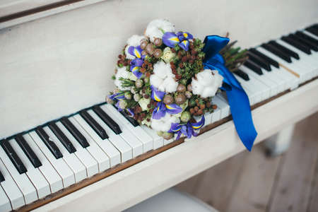 Beautiful winter wedding bouquet with cones, cotton and spruce branches. Bride holding a bridal bouquet.の写真素材