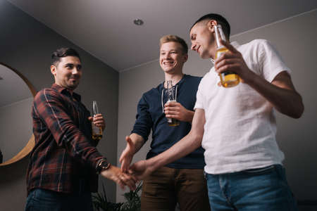 Friends make bets. Guy breaks his friends handshake with his hand. Two men bet during a sports match...