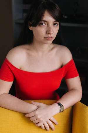 Luxurious young woman in sexy red dress looks at the camera. Pretty girl in provocative bright clothes.の写真素材