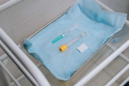 Close-up of nurse wearing medical gloves takes syringe for drawing blood. Preparation for medical procedures. View from above. Concept of healthcare and medicine. Concept of healthcare and medicine.の写真素材