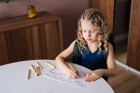 Adorable happy little girl drawing with pencils at home. Concept of child creative activity.の写真素材