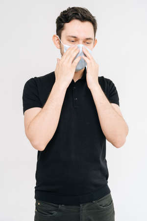 Caucasian young man with protecting from the coronavirus with medical mask over white isolated background pointing to the face and mask. Prevention of virus infection, Coronavirus COVID-19.の写真素材