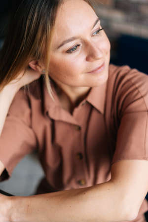Close-up portrait of face of blonde woman sitting at chair in the living room. Concept of home coziness .の写真素材