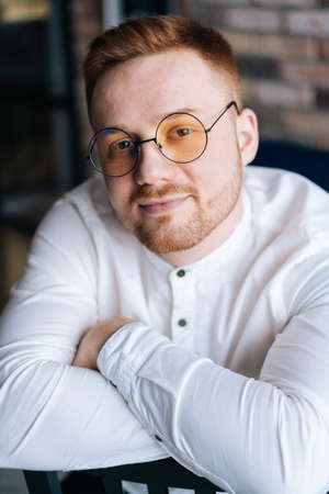 Elegance attractive man in fashion glasses looking at the camera, crossed hands.の写真素材