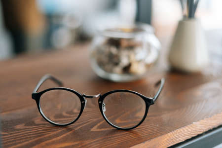 Stylish glasses on the wooden table in modern office room, no people.の写真素材