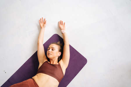 High-angle shot of fit young woman with perfect athletic body wearing sportswear working out lying...
