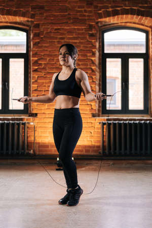 Vertical shot of fitness young athletic woman with strong beautiful body in sportswear exercising...