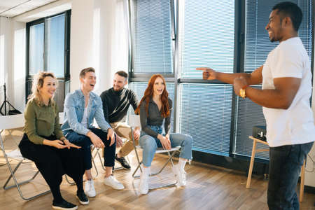 Group of young diverse multiethnic colleagues playing in active games during team building in modern...