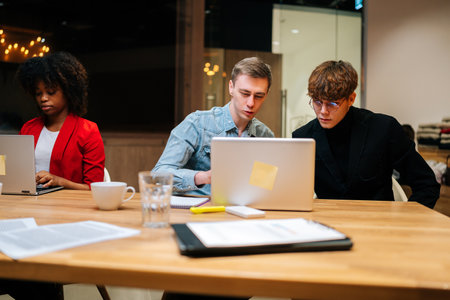 Portrait of young creative business team discussing online project working together on laptop...