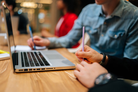 Close-up cropped shot of unrecognizable businesspeople discussing paper reports with sticky notes, analyzing marketing, statistic data, working on project together. Concept of creative business teamの写真素材