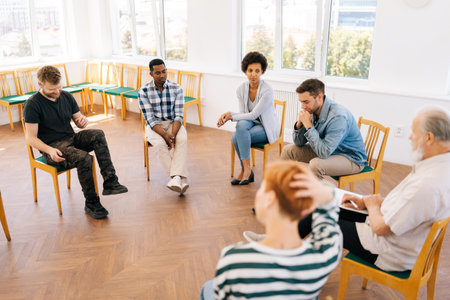 Wide shot of community, support and psychology with diverse and different ages people in workshop for teamwork, mental health or empathy. Human resources, communication or team building.の写真素材