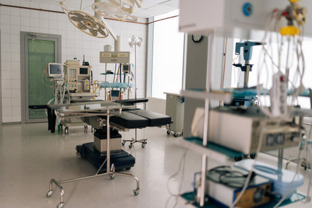 Light interior of modern operating room and equipment in hospital, no people. Medical device for surgeon surgical emergency patient. Light clean surgical theatre with diverse equipment.の写真素材