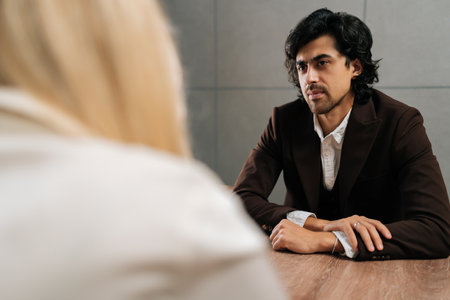 Back view of unrecognizable businesswoman having meeting with serious male colleague in office....