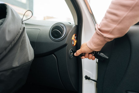 Close-up cropped shot of unrecognizable young woman turns off passenger airbag using key for placing...