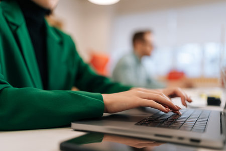 Close-up hands of unrecognizable female programmer typing program code on laptop keyboard in...