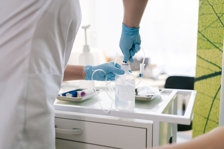 Cropped shot of professional unrecognizable female nurse preparing IV pole for patient in hospital. Closeup hands of medical worker preparing drop counter for procedure for sick patient in clinic.の写真素材