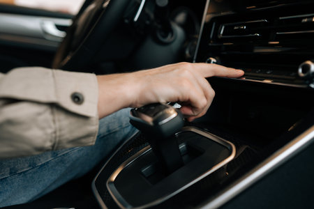 Closeup hands of unrecognizable driver male choosing favorite radio. Man pressing button on vehicle...