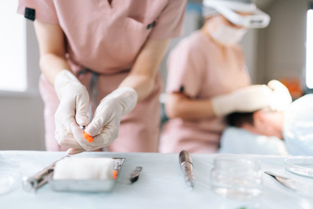 Close-up cropped shot of unrecognizable nurse assistant removing cap from needle of syringe,...