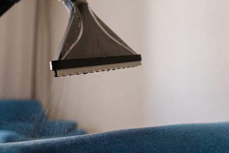 Close-up cropped shot of unrecognizable man cleaning blue sofa with washing vacuum cleaner designed for furniture, ensuring deep cleaning and sanitizing for fresh hygienic home environment, closeupの写真素材