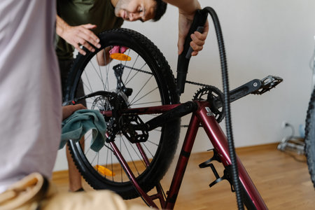 Professional mechanics steam-cleaning mountain bike wheel, focusing on maintenance and thorough dirt removal within workshop setting, close-up. Concept of professional bike service.の写真素材