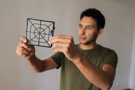 Medium shot portrait of male professional cleaning air humidifier filter, maintaining indoor air quality and ensuring optimal device performance for healthier living space. Concept of cleanliness.の写真素材