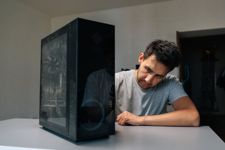 Portrait of computer repair professional gesturing toward dust-clogged air vents, highlighting...