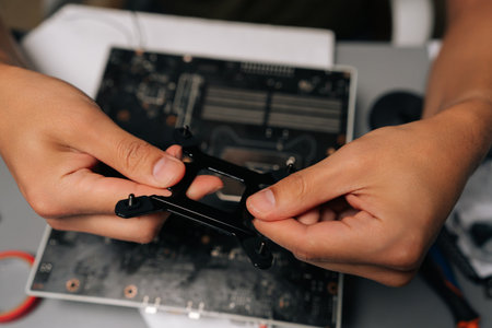 Top view of computer technician mounting CPU cooler bracket on motherboard, ensuring precise...