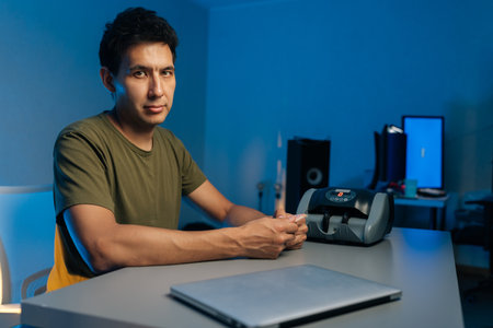 Portrait of cashier organizing currency for automated counting machine during nighttime office...