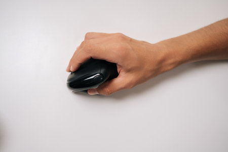 Close-up top view of male hand holding vertical ergonomic mouse on white background, highlighting...