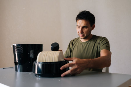 Professional cleaning service employee maintaining air humidifier filter, ensuring clean indoor air quality and optimal respiratory health in home environment. Concept of maintenance home appliance.の写真素材