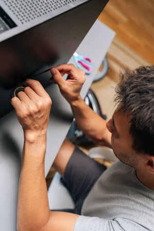 Vertical top view of technician applying black electrical tape while performing computer case...