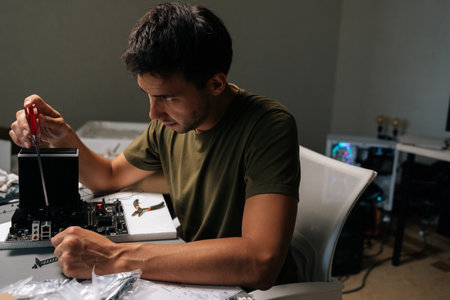 Computer technician installing CPU cooler on motherboard, handling delicate computer hardware during...