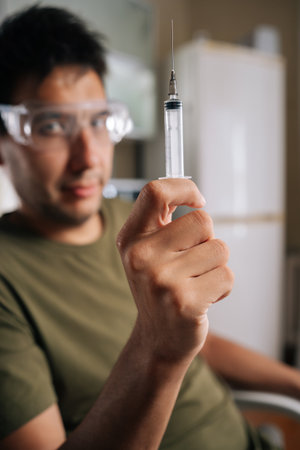 Selective focus portrait of chemist wearing safety glasses carefully preparing fertilizer using...