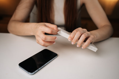 Cropped shot of woman opening white retail box containing new phone cable adapter, holding over...