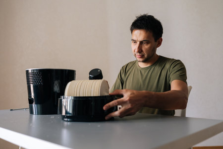 Serious cleaning service employee male maintaining air humidifier filter, ensuring clean indoor air...