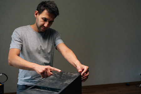 Computer technician pointing at layer of dust on computer case, highlighting need for cleaning service to maintain optimal performance and prevent overheating. Concept of service, cleaning computer.の写真素材