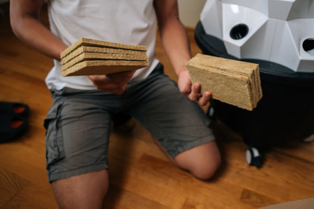 Cropped shot of unrecognizable gardener holding rockwool slabs, preparing to plant seeds in modern hydroponic tower garden, showcasing innovative and sustainable urban farming techniques.の写真素材