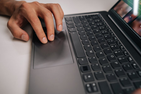 Businessman hand navigating touchpad on laptop keyboard during online meeting, emphasizing essence...