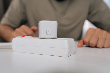 Person setting up smart home technology, connecting smart plug into power strip, demonstrating...