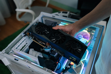 Hands of computer technician using screwdriver to assemble and service internal components of...