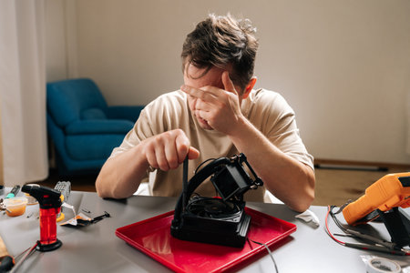 Man struggling with complex computer cooling system repair, feeling frustrated and stressed while...