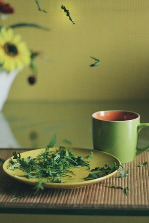 Tender leaves and cup of tea with pomegranate
