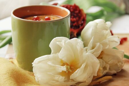 Tender white flower and cup of tea with pomegranateの写真素材