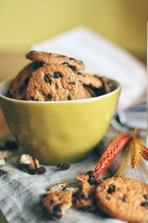 Breakfest. Tasty cookies or biscuits with chocolate on the napkin at kitchen table. Feel the home comfort with sweets. Delicious food and drinks concept, healthy eating for morning. Warm colors.の写真素材