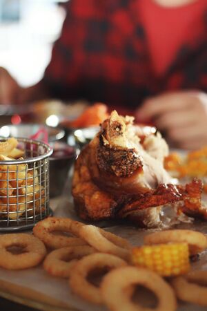 Close up of pork knuckle with snacks and sauce on the pub's table background. Tasty drinks and food. Oktoberfest traditions, delicious snacks, festival, alcohol, friend's time, chilling, resting.の写真素材