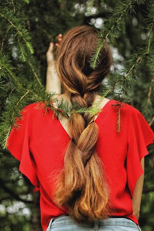Young pretty brunette caucasian girl on green park on background. Looks confident, attractive. Human emotions, feelings, beauty, fashion. Bright colors. Summer story, youth concept. Art portrait.の写真素材